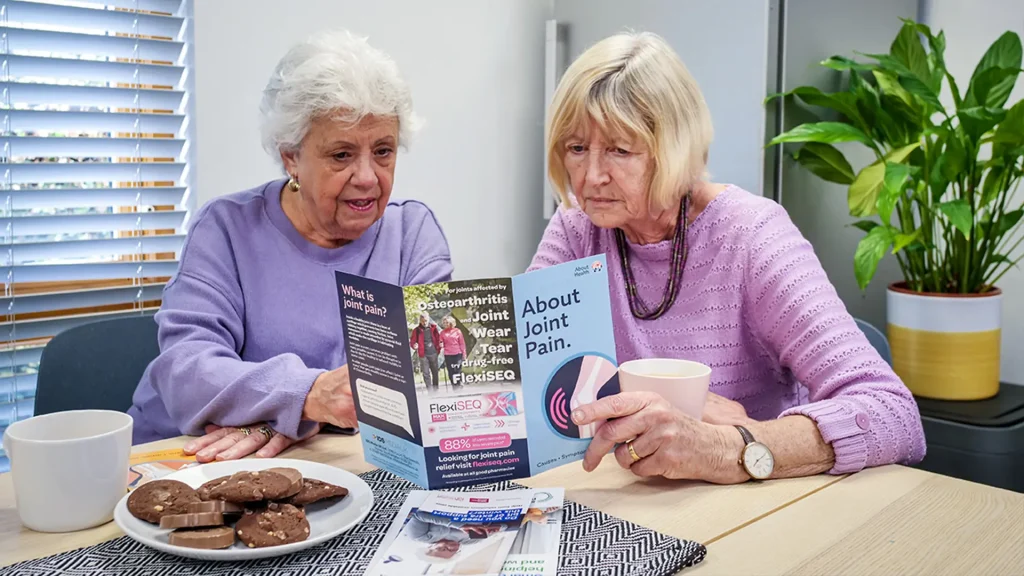 Two elderly women reading a leaflet