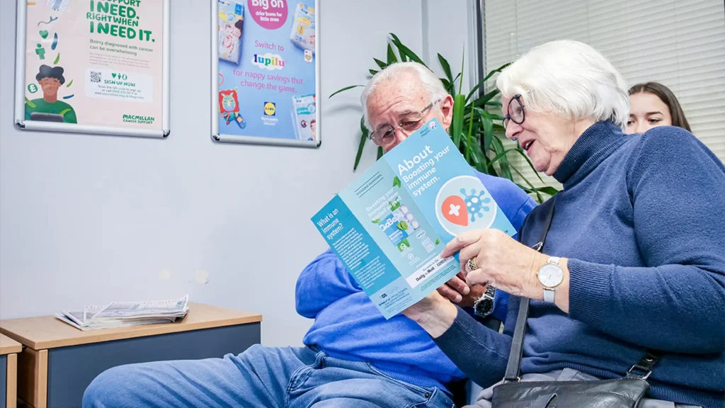 Patients reading a leaflet in a GP waiting room