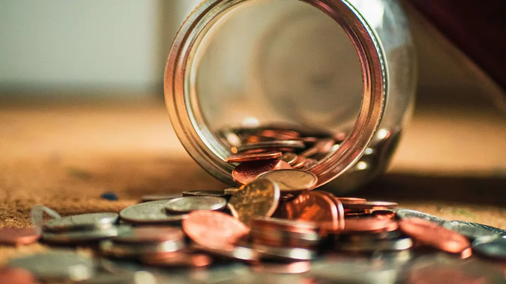 Coins falling out of a glass jar